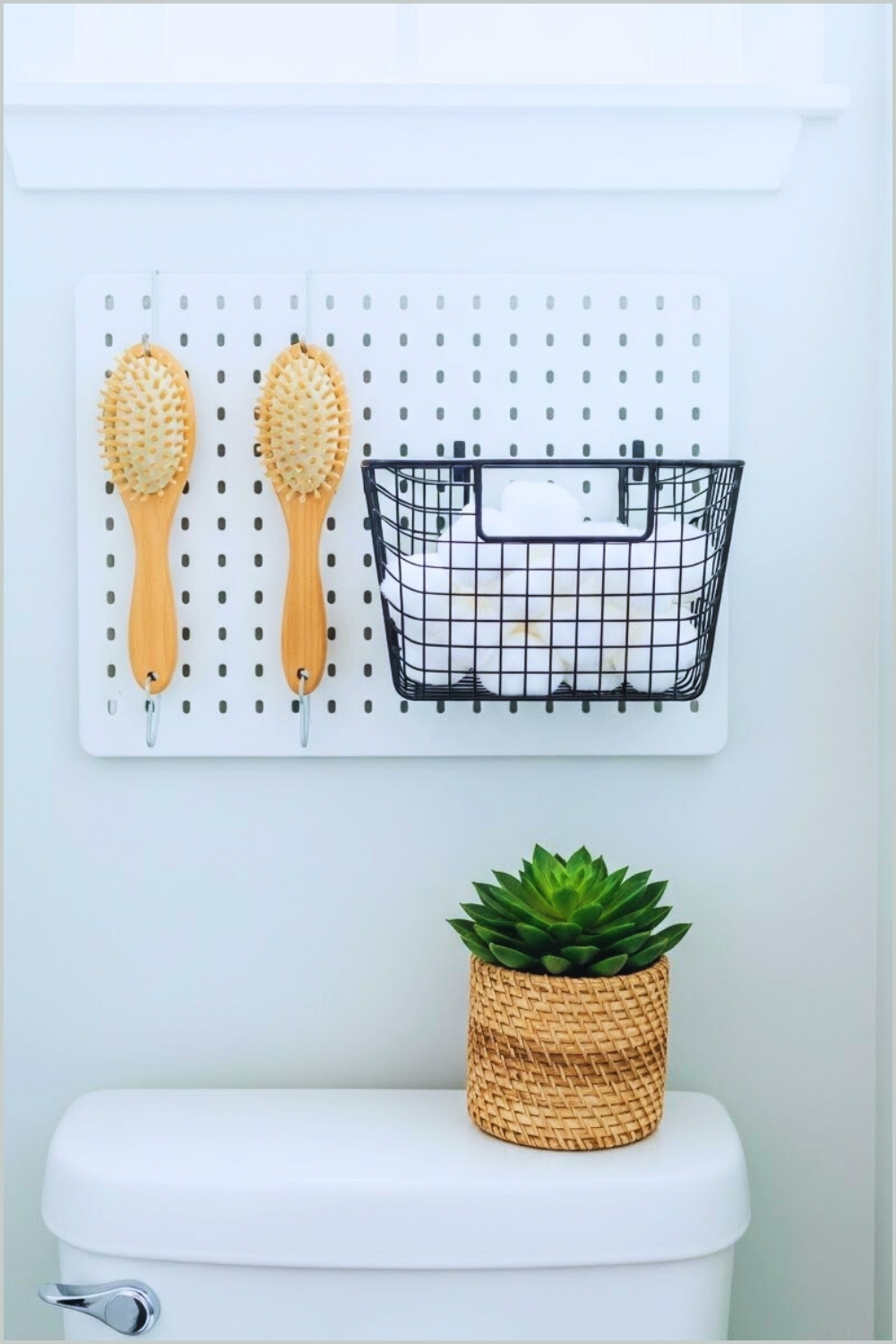 Minimal White Bathroom With Pegboard Above Toilet Tank